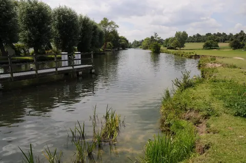 The River Thames at Shiplake Lock with boats and trees along the bank.